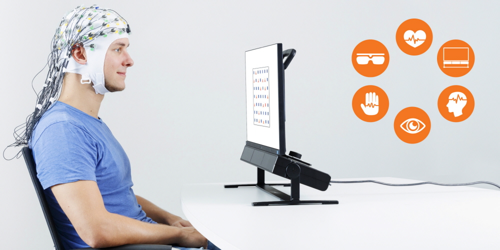 A person wearing EEG cap in front of the Tobii Pro Spectrum eye tracker