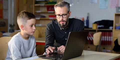 Man using an eye tracker on a laptop to test a student