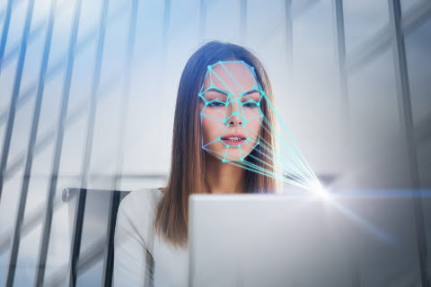Woman looking at a computer emotion recognition