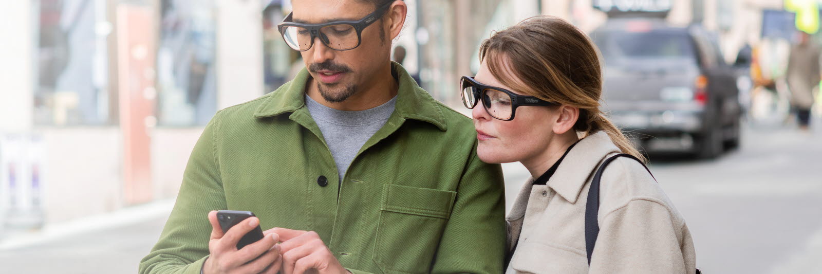 A couple wearing Tobii Pro Glasses 3 looking at a mobile