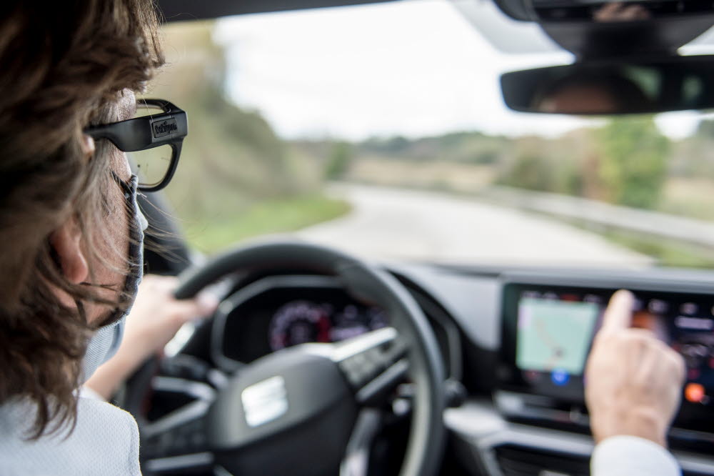A man driving a car while wearable Tobii Pro Glasses 3 wearable eye trackers